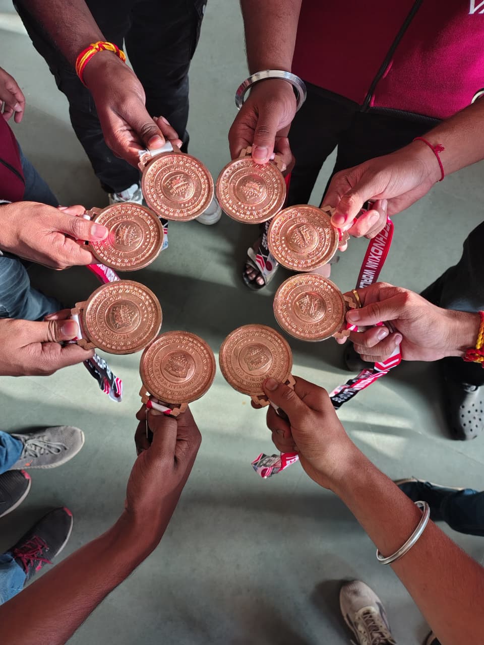 Team Vajra members holding medals in a circle